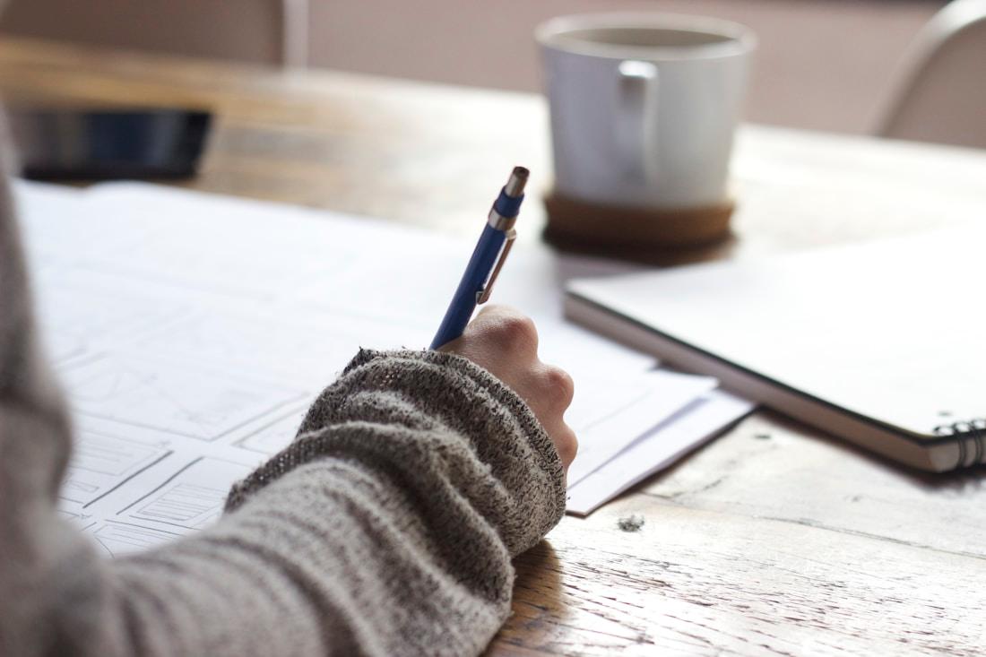 A student studying at a desk, focused on academic work.